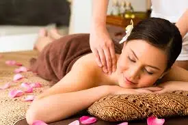 A calming spa setting where a client receives a full-body massage from a professional therapist in a softly lit room. Clean linens, aromatic oils, and a tranquil atmosphere create a relaxing experience focused on stress relief, muscle relaxation, and overall wellness in a private, comfortable environment designed for rejuvenation and peace.